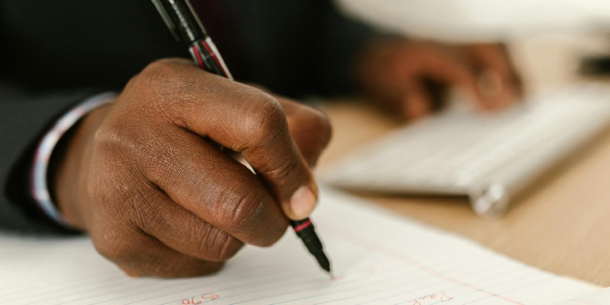 A person diligently writing notes, illustrating the process of preparing for an important therapy appointment.