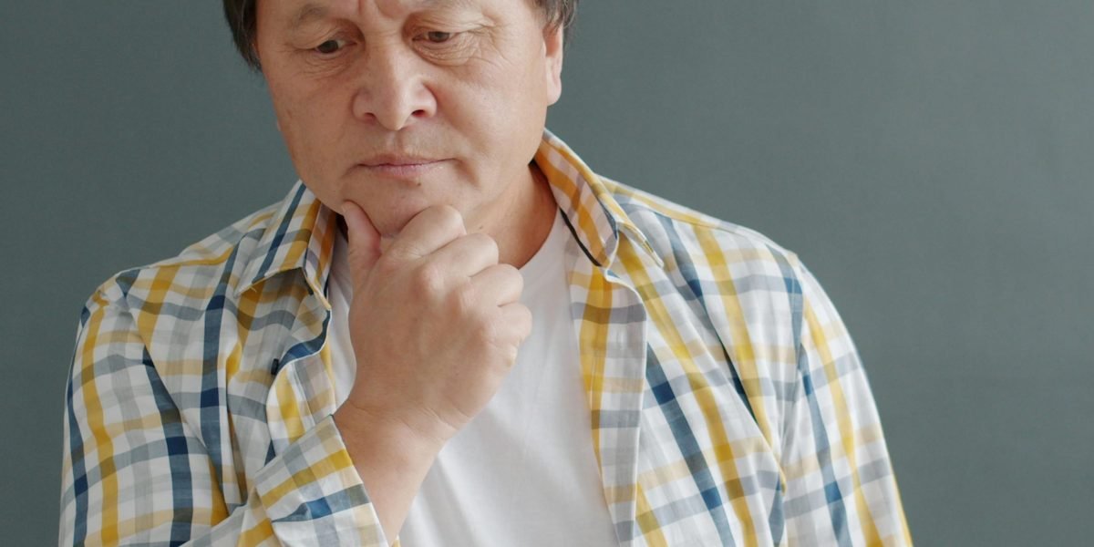 A person in a thoughtful pose, reflecting the serious impact of mental health challenges and stigma.