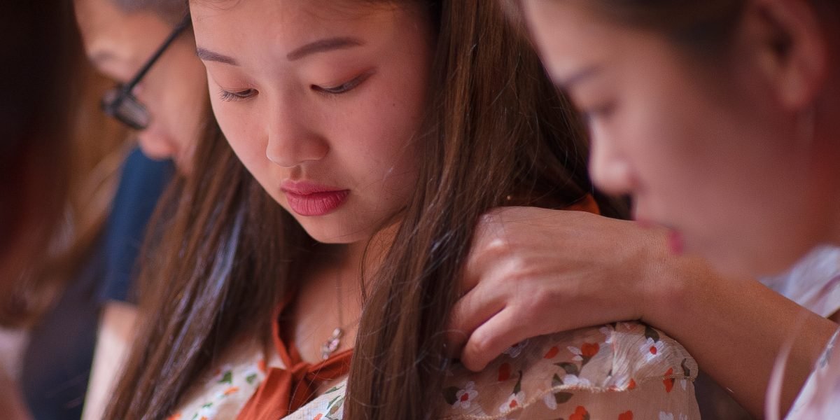 A person exhibiting signs of social anxiety in a busy social environment, reflecting internal discomfort.