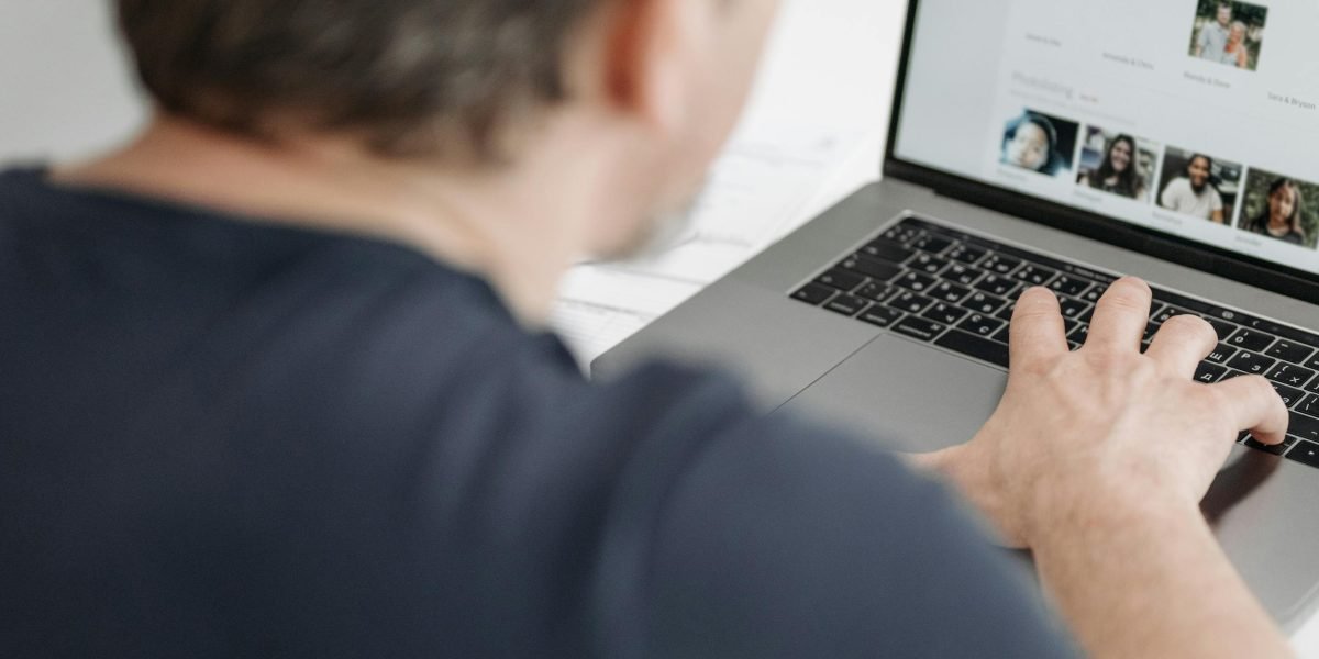 A person using a laptop to research mental health resources, focusing on finding a suitable therapist.