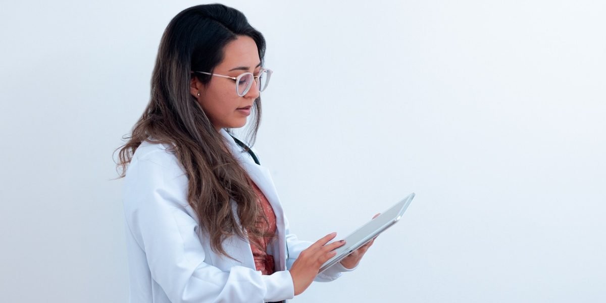 A healthcare professional and patient review digital health information together on a tablet.