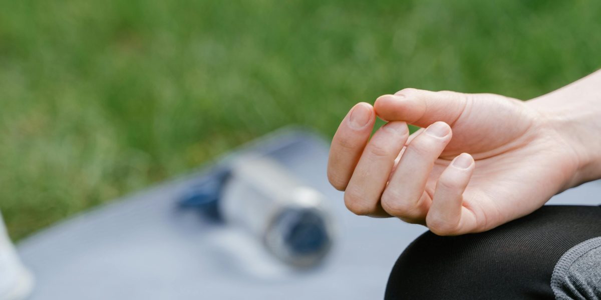 A person practices mindfulness in a serene outdoor setting, aiding stress reduction and mental clarity.