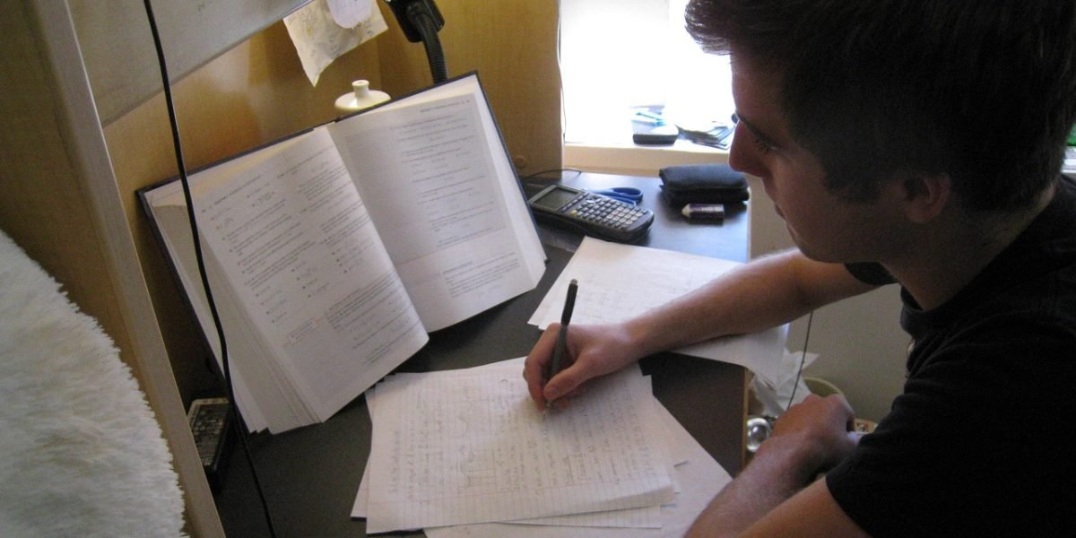 A student focused on studying textbooks and notes, reflecting the rigorous educational pathway for mental health counselors.