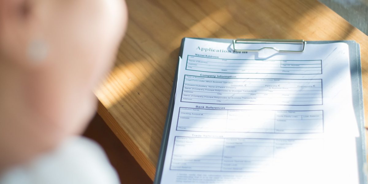 A person organizing documents for a graduate program application.